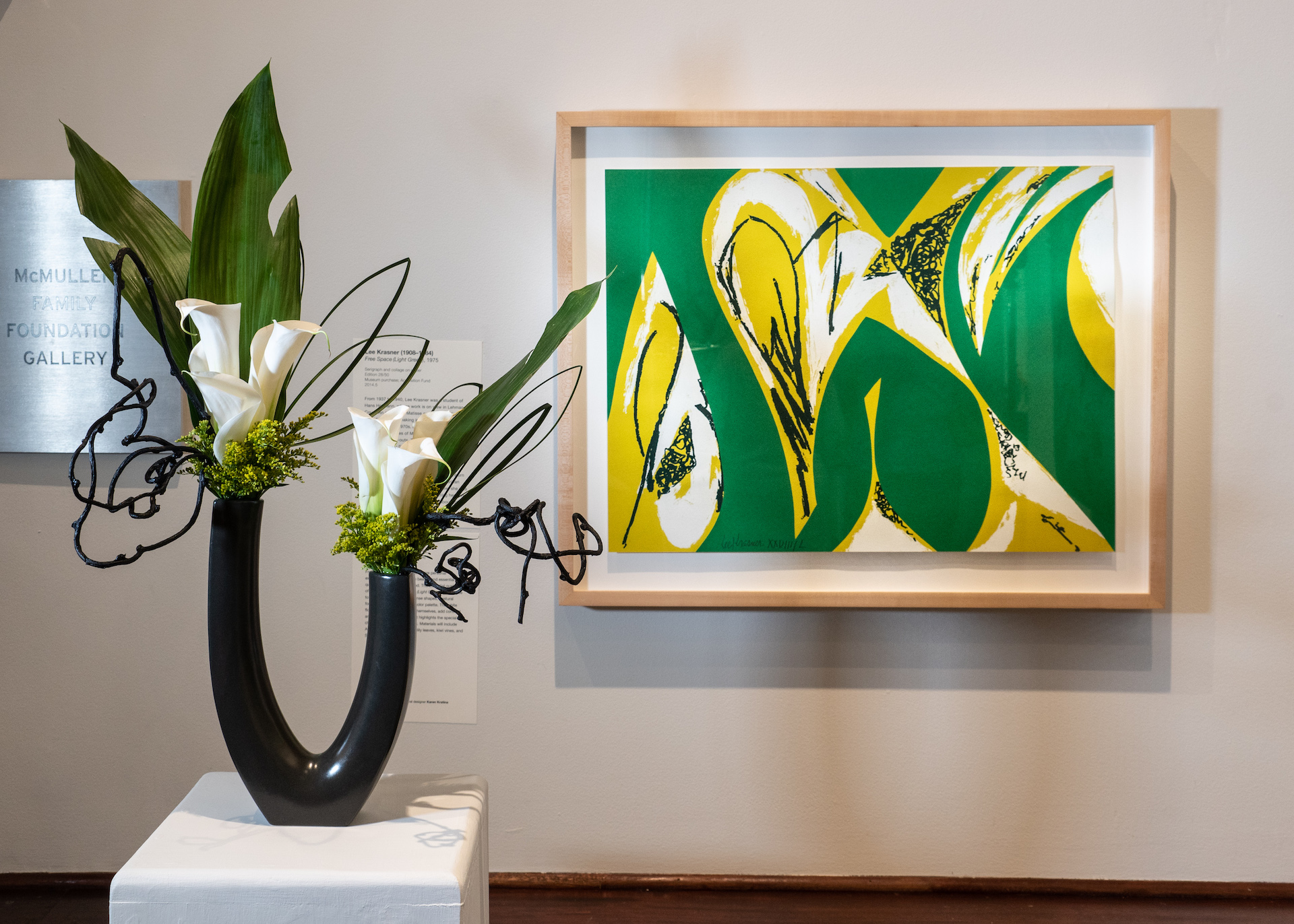 A sculptural floral arrangement in front of the artwork that inspired it in the gallery.