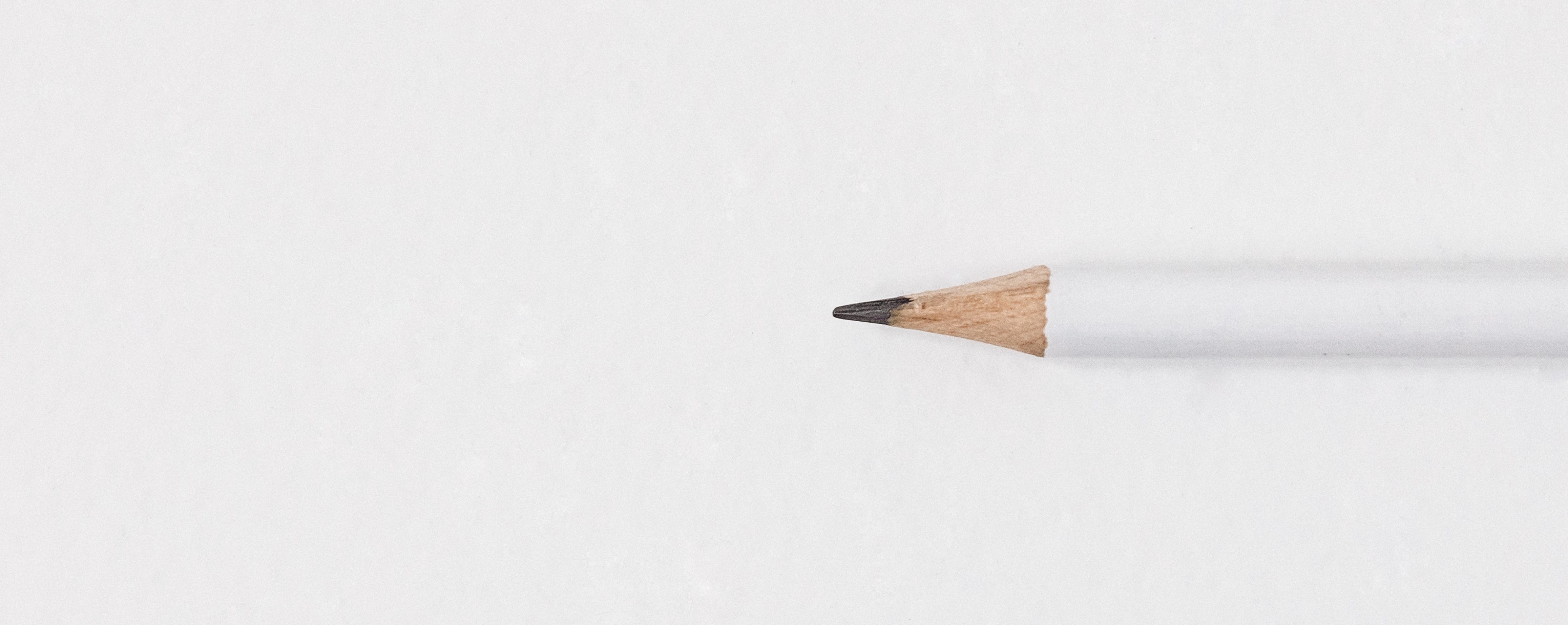 a pencil sitting on a white surface