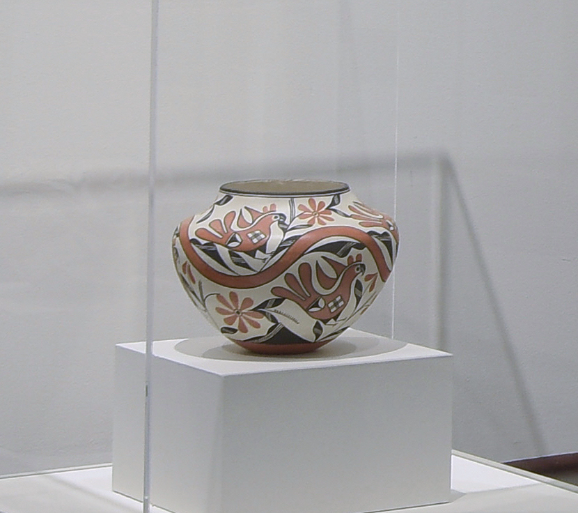 a traditional hanndmade ceramic pot in a glass case in a MAM gallery.