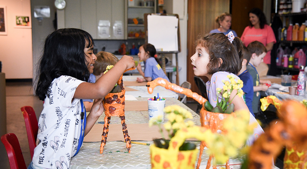 Two girls making paper mache flower pots during SummerART Camp