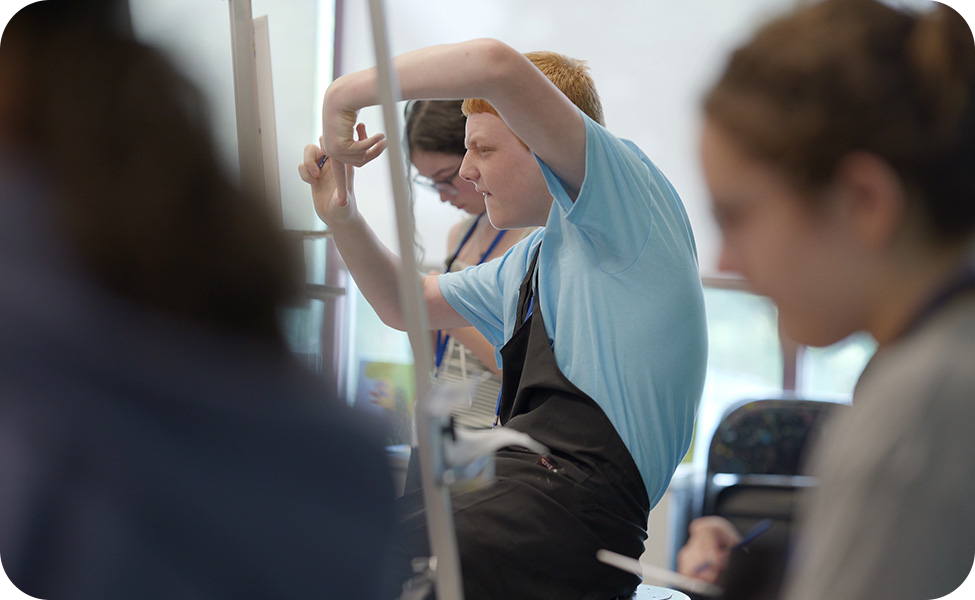 Teen siting at a painter's easel