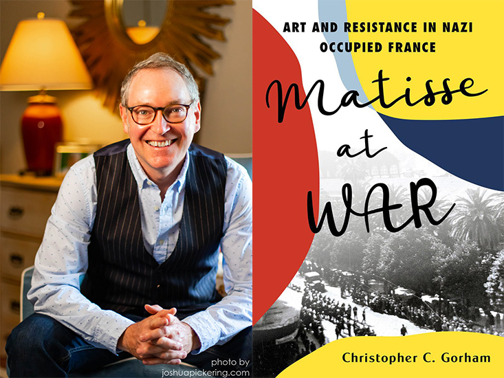 A man in a striped vest sits beside the book cover "Matisse at War" by Christopher C. Gorham, highlighting art in Nazi-occupied France.