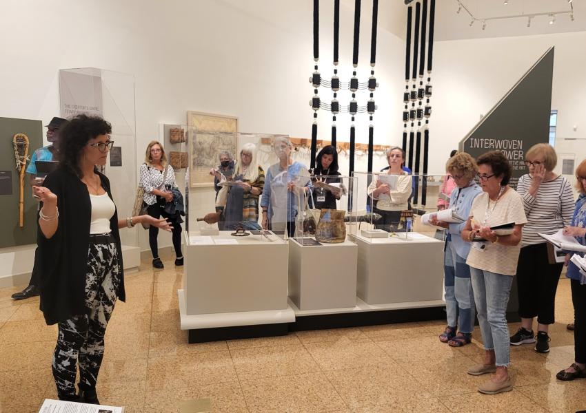 MAM docents receiving a guided tour of "Interwoven Power: Native Knowledge / Native Art" from Curator of Native American Art Laura Allen