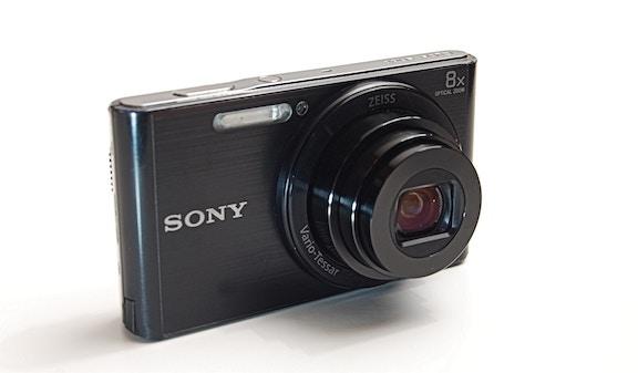 A small, black Sony point-and-shoot camera on a white background.