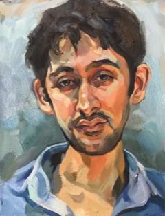 A portrait of a man in a blue collared shirt.