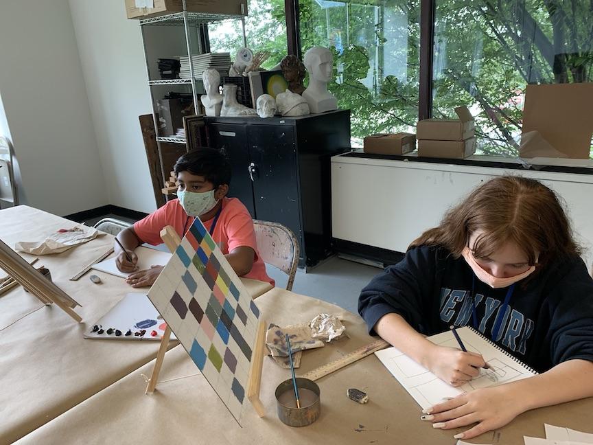 Two students are working on projects at the same table.