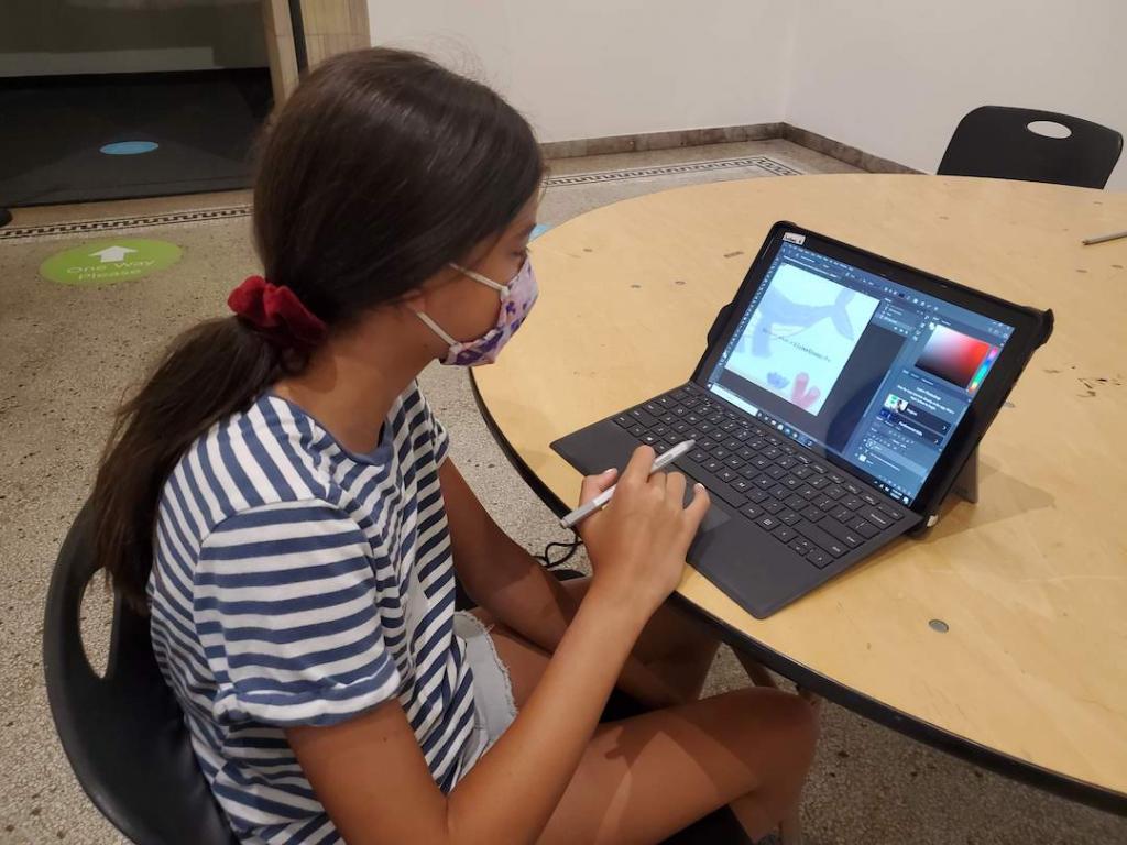 A young student working on a surface pro tablet.