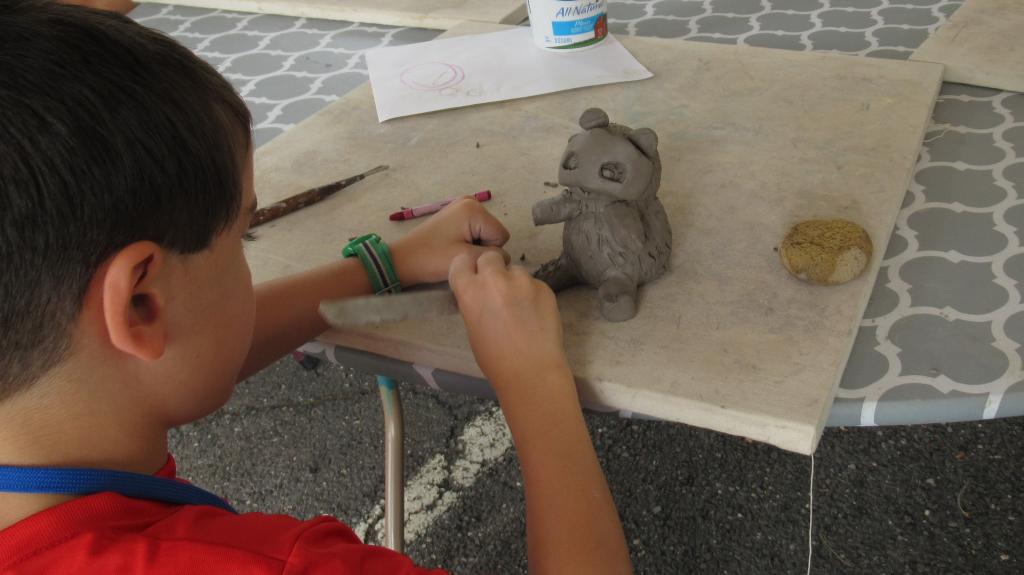 Camper molding an animal figurine in SummerART Camp (Ceramic Hand-building)