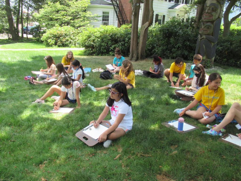Campers sitting in MAM's grounds drawing as part of SummerART Drawing and Painting: In the Great Outdoors