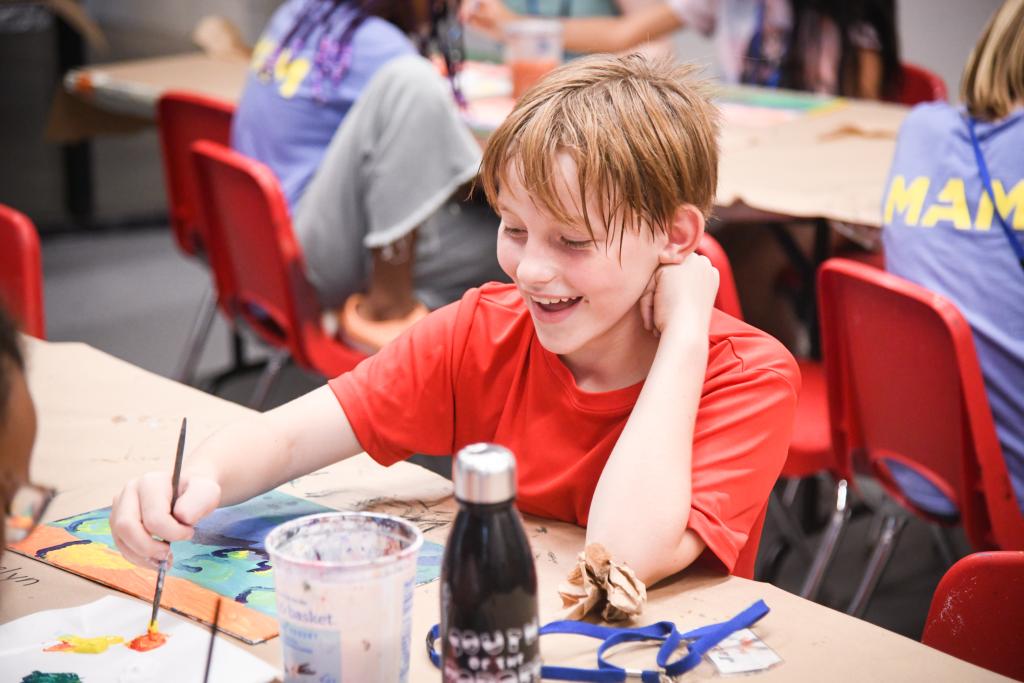 Student painting at a table in a MAM studio