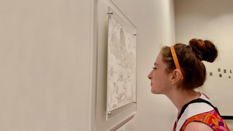 Guest admiring art in "Lori Field: Tiger Tarot" exhibition
