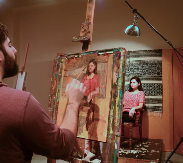 A student is painting a live model in class.