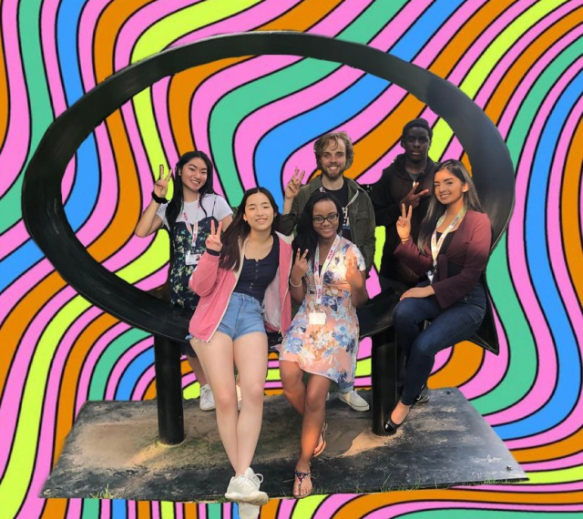 The 2019 teen intern group sitting on a sculpture at MAM with the background photoshopped to be psychedelic rainbow lines.