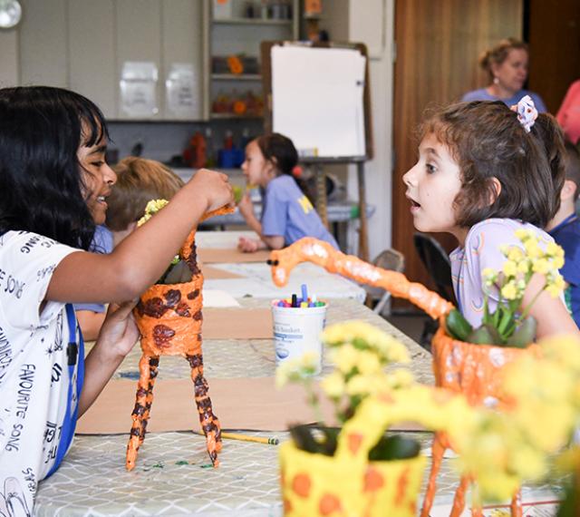 Two girls making paper mache flower pots during SummerART Camp