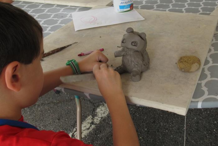 Camper molding an animal figurine in SummerART Camp (Ceramic Hand-building)