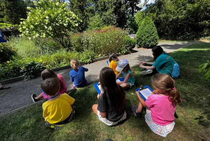 Campers sitting in Van Vleck Gardens drawing as part of SummerART at Van Vleck