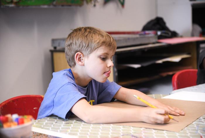 A young student is drawing in a MAM studio.