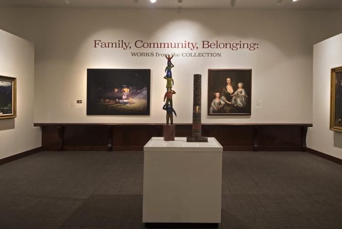 Art gallery interior with a sculpture in the foreground and two framed artworks on the wall under a 